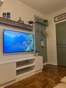 uma sala de estar com uma televisão de ecrã plano na parede em Arce 23 em Buenos Aires