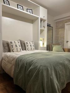 a white bedroom with a large bed with pillows at Arce 23 in Buenos Aires