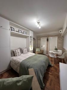 um quarto com uma cama e uma mesa num quarto em Arce 23 em Buenos Aires