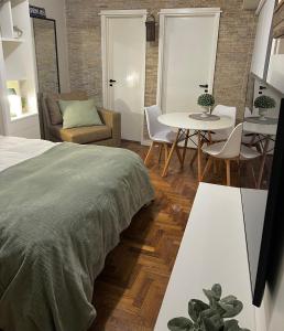 1 dormitorio con 1 cama, mesa y sillas en Arce 23 en Buenos Aires