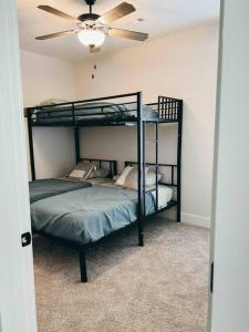 a bedroom with two bunk beds and a ceiling fan at Cozy Coastal Bungalow in Opelika