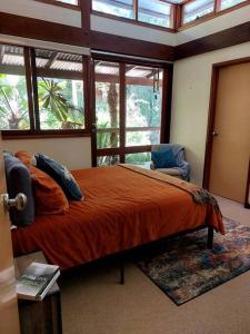 Un dormitorio con una cama grande y una ventana en Heartwood Hill, en Uki