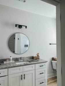 een badkamer met een wastafel en een spiegel bij Cozy Coastal Bungalow in Opelika