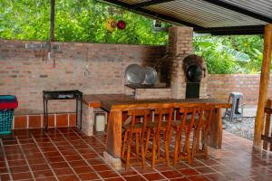eine Außenküche mit einem Holztisch und Stühlen in der Unterkunft Hacienda Mi Rancho in Villavicencio