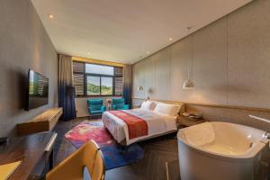 a hotel room with a bed and a tub and a bedroom at Nanxianglou Art Hotel in Shenzhen