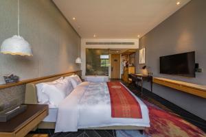 a bedroom with a large bed and a flat screen tv at Nanxianglou Art Hotel in Shenzhen