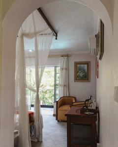 una sala de estar con una cortina blanca y una ventana en Jacaranda Lodge, en Victoria Falls