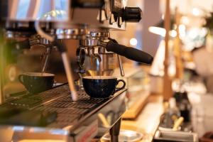 two cups of coffee are on a coffee machine at CAFE/MINIMAL HOTEL OUR OUR in Tokyo