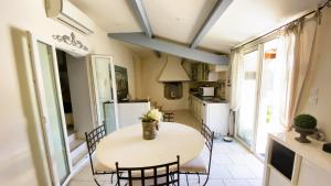 Il comprend une cuisine équipée d'une table, de chaises et d'un réfrigérateur. dans l'établissement Villa Provençale avec piscine privative, à Saint-Cyr-sur-Mer