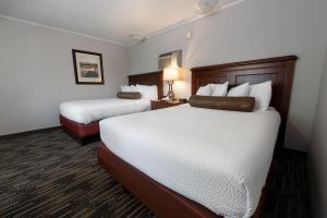 a hotel room with two beds and a lamp at Scotty's Lakeside Resort in Lake George