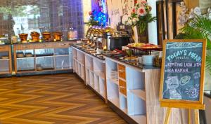 uma linha de buffet com comida e um sinal em Odaita Hotel Pamekasan Madura em Pademabu