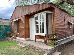 una pequeña casa con porche y puerta en Cabaña Terra Calma en Vistalba