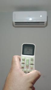 a person holding a calculator in their hand at Casa a 5 km de Luziânia 1 quarto com ar-condicionado in Cidade Ocidental