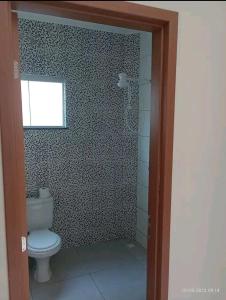 a bathroom with a toilet and a window at Casa a 5 km de Luziânia 1 quarto com ar-condicionado in Cidade Ocidental