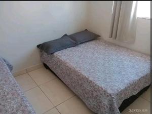 a small bed with a blue pillow in a room at Casa a 5 km de Luziânia 1 quarto com ar-condicionado in Cidade Ocidental
