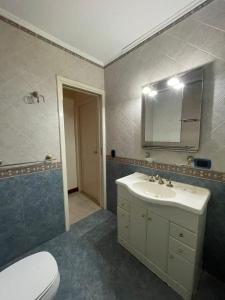 ein Badezimmer mit einem Waschbecken, einem Spiegel und einem WC in der Unterkunft La casa de Cate in Mar de Ajó