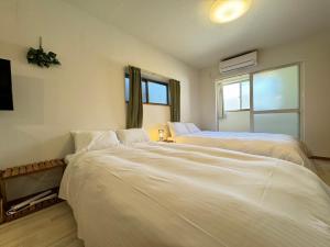 1 dormitorio con 2 camas y ventana en マルチステイ大阪天保山22 en Osaka