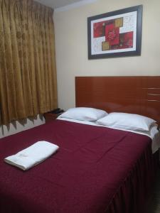 a bedroom with a bed with two towels on it at Hotel lucero real in Tacna