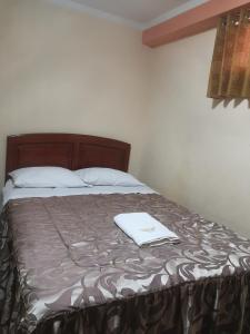 un letto con una coperta marrone e bianca. di Hotel lucero real a Tacna