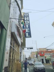 Un uomo che cammina per una strada di fronte a un edificio di Hotel lucero real a Tacna