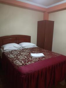 a bed with two white towels on top of it at Hotel lucero real in Tacna