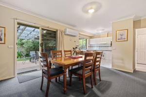 a kitchen and dining room with a wooden table and chairs at Happy Paws Bright Hideaway in Bright