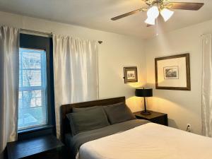 1 dormitorio con 1 cama, ventilador de techo y ventana en Comfy Home With Gated Garden I Family Reunion, en Oklahoma City