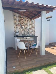 a patio with a table and chairs under a pergola at Casa de praia Jauá in Camaçari