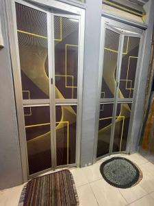 ROYAL LILY TANAH RATA BY JUNIKASTAY في تاناه راتا: غرفة مع أبواب زجاجية منزلقة وسجادة