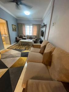 a living room with a couch and a living room at ROYAL LILY TANAH RATA BY JUNIKASTAY in Tanah Rata