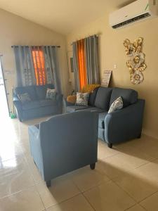 ein Wohnzimmer mit zwei blauen Sofas in der Unterkunft Finest Accommodation Lot 1577 Phoenix Park Phase 4 Portmore St Catherine 