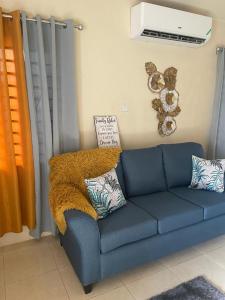a blue couch with a furry blanket sitting in a living room at Finest Accommodation Lot 1577 Phoenix Park Phase 4 Portmore St Catherine 