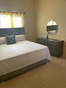 a bedroom with a large bed and a mirror at Finest Accommodation Lot 1577 Phoenix Park Phase 4 Portmore St Catherine 