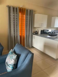 a living room with a couch and a kitchen at Finest Accommodation Lot 1577 Phoenix Park Phase 4 Portmore St Catherine 