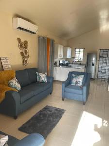 ein Wohnzimmer mit einem Sofa und einem Stuhl in der Unterkunft Finest Accommodation Lot 1577 Phoenix Park Phase 4 Portmore St Catherine 