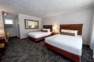 a hotel room with two beds and a desk at Scotty's Lakeside Resort in Lake George