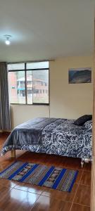 uma cama num quarto com uma grande janela em Casa de George em Urubamba