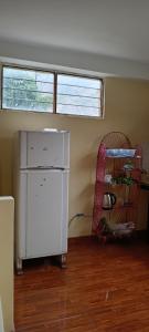 um quarto vazio com um frigorífico branco e uma janela em Casa de George em Urubamba