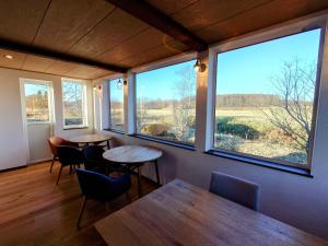 two tables and chairs in a room with windows at Tsukushi Village in Tsurui