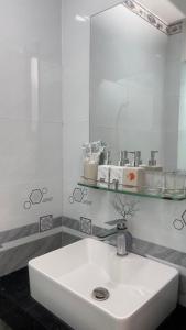 a white bathroom with a sink and a mirror at ALEX HOTEL in Ho Chi Minh City