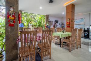 a dining room with a green table and chairs at The Kutaya in Kuta