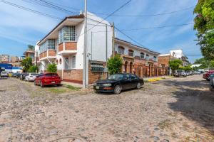 a street with cars parked in front of a building at Hacienda Lord Twigg - Hotel & Suites in Puerto Vallarta