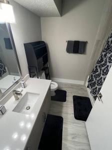 Baño blanco con lavabo y aseo en Cozy LED Condo: 2BR, 2BA Apt, en Charlotte
