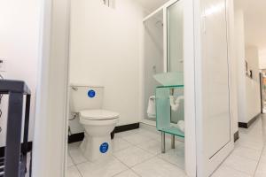 uma casa de banho com um WC e uma cadeira azul em Mangoya Lounge 