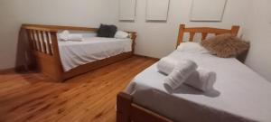 two beds in a room with wooden floors at Dpto Tiempo Presente in Colón