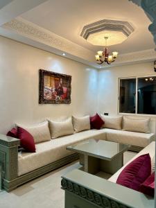 uma sala de estar com um sofá e uma mesa em Appartement de luxe Marrakech Menara em Marrakech