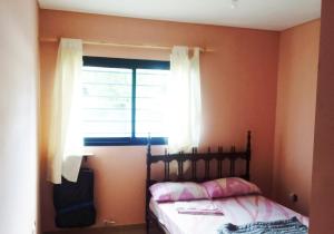 a bedroom with a bed and a window at House, Summer in Villa Gesell