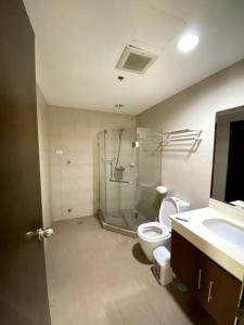 y baño con ducha, aseo y lavamanos. en The Pagdett Place - Unit 1502, en Cebú