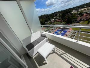 uma cadeira branca sentada numa varanda com vista em Punta del Este - Green Life - Top amenities em Punta del Este