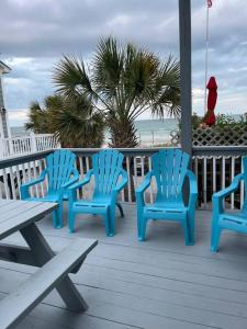 Tres sillas azules sentadas en una terraza cerca de la playa en Endless Summer Beach House, en Myrtle Beach